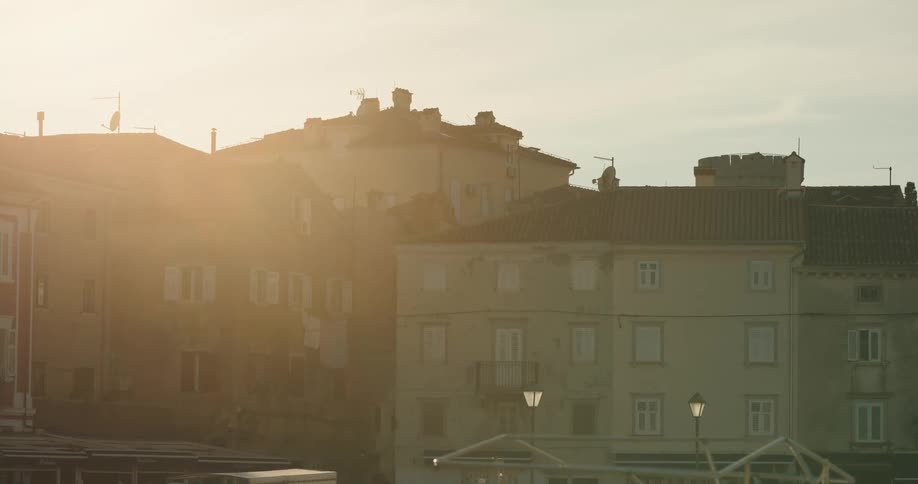 Sunlight over the rooftops of the buildings on a small town at sunset