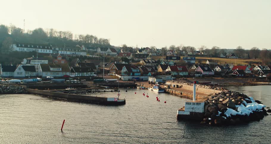 Aerial view of the bay in front of a a calm small coastal town close to the ocean at morning