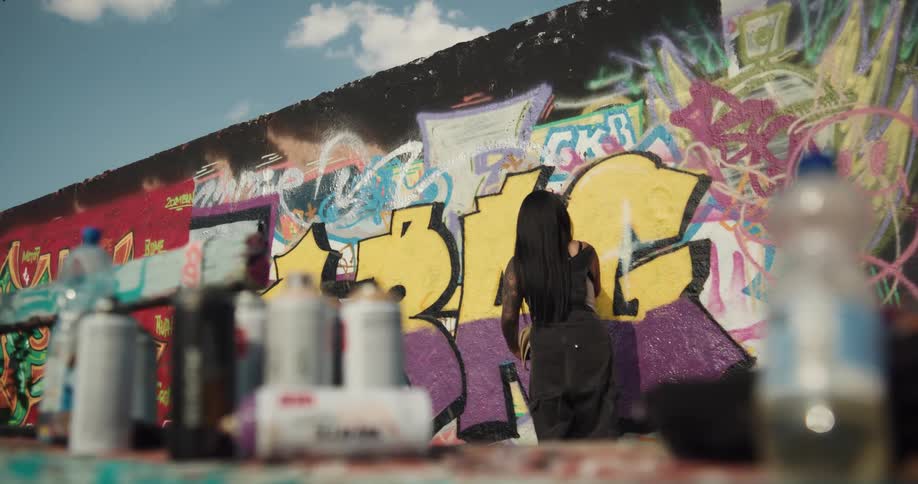A woman is spray painting the wall