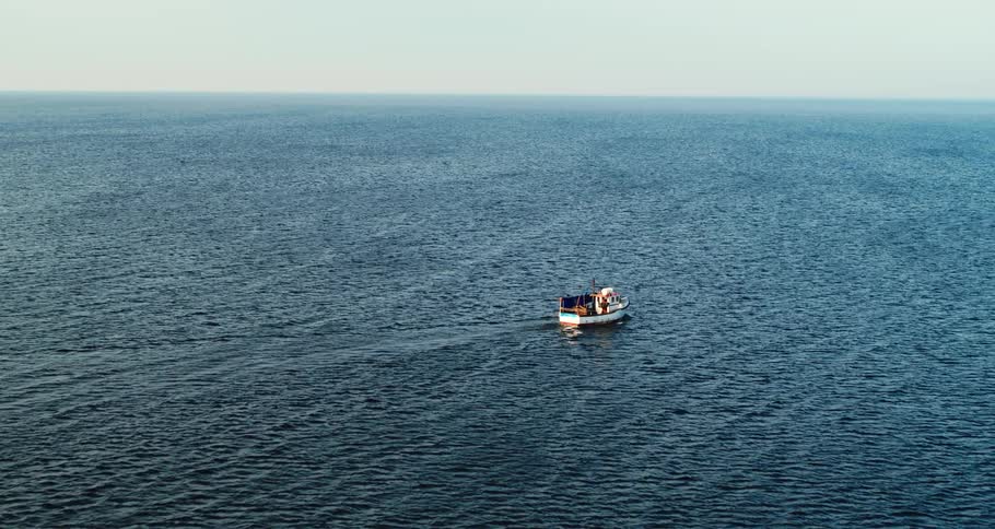 A boat travels across the open ocean during the day