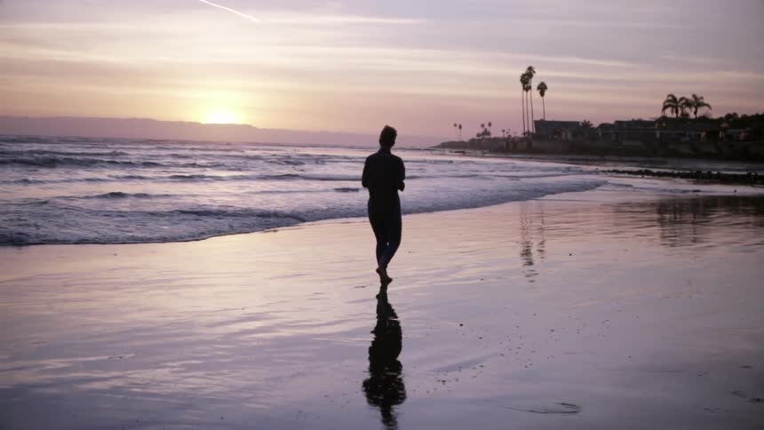 A person is walking along the beach