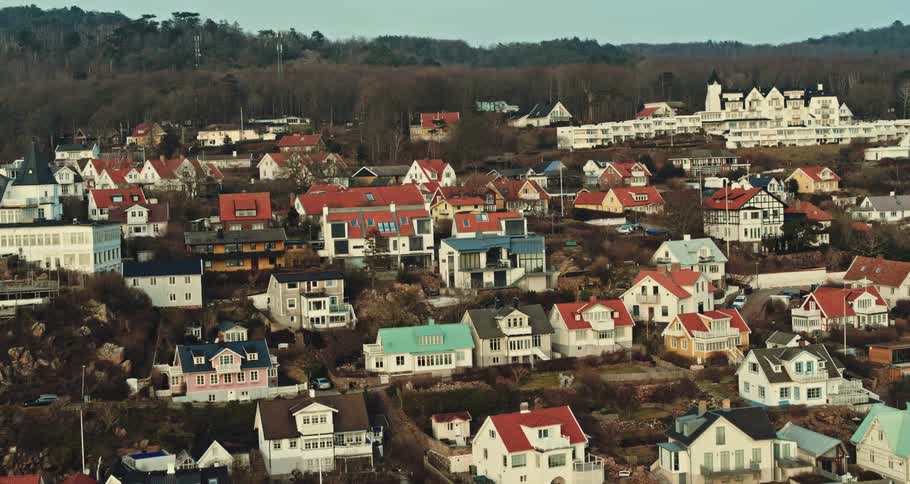 White homes with colorful roofs line a coastal neighborhood