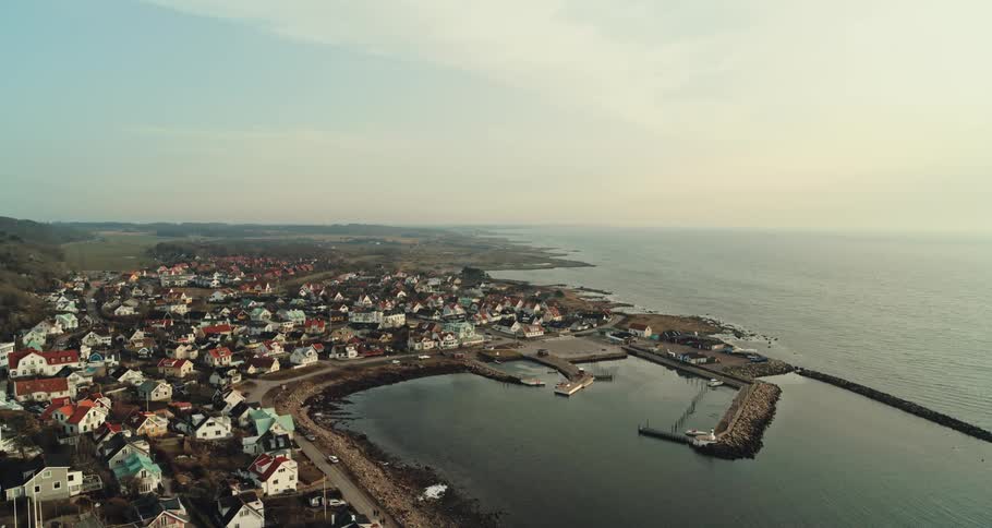 Aerial view of the bay in front of a a calm small coastal town close to the ocean at morning