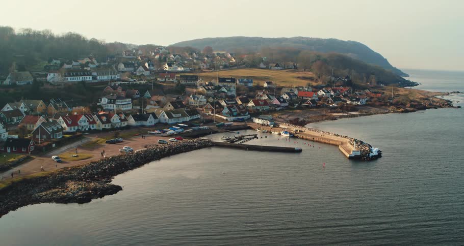 Aerial view of coastal town with detached houses pier and boats
