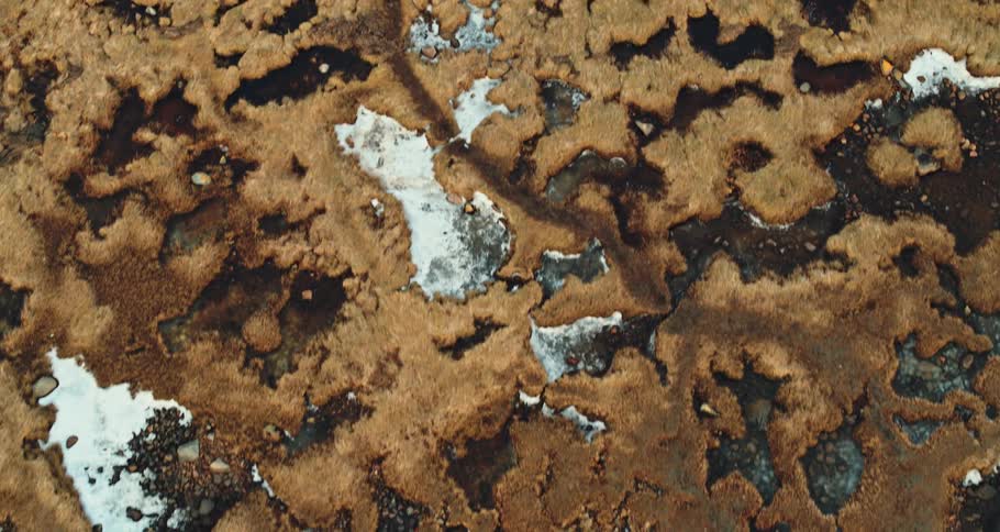 An aerial view of rocks and sand on the beach