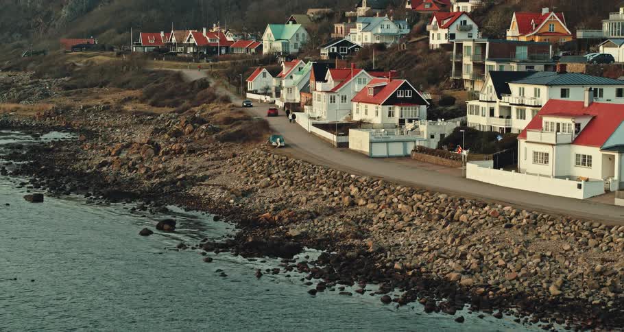 A road along the coast of a small hillside town during the day