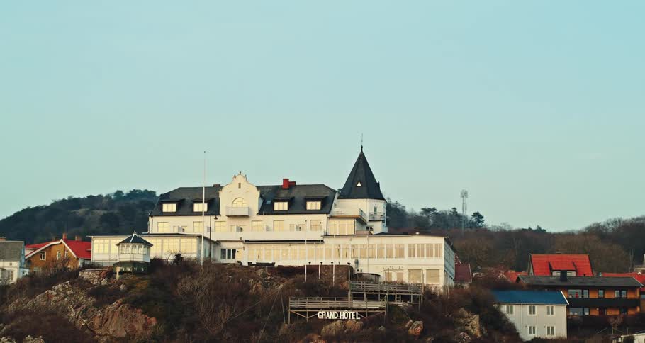 Aerial view of an hotel on the top of a hill on a small town at evening