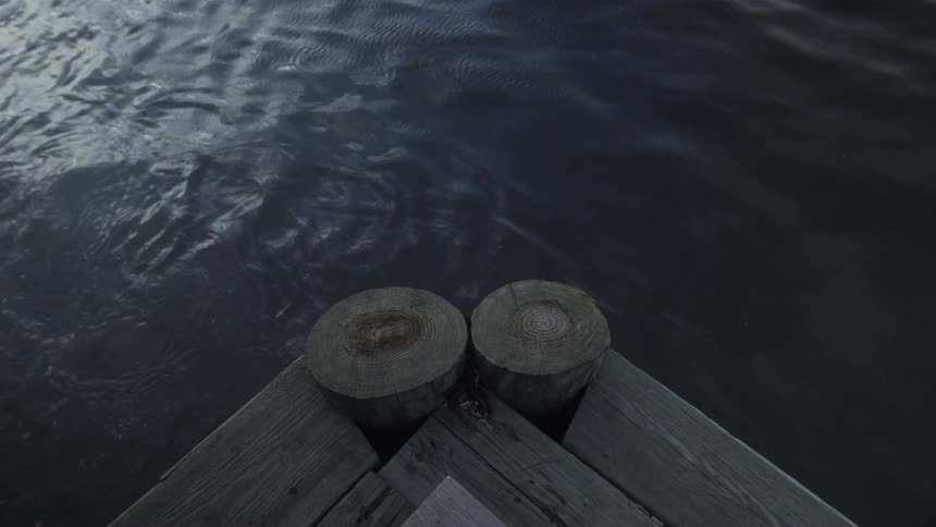 A wooden dock has water on the side