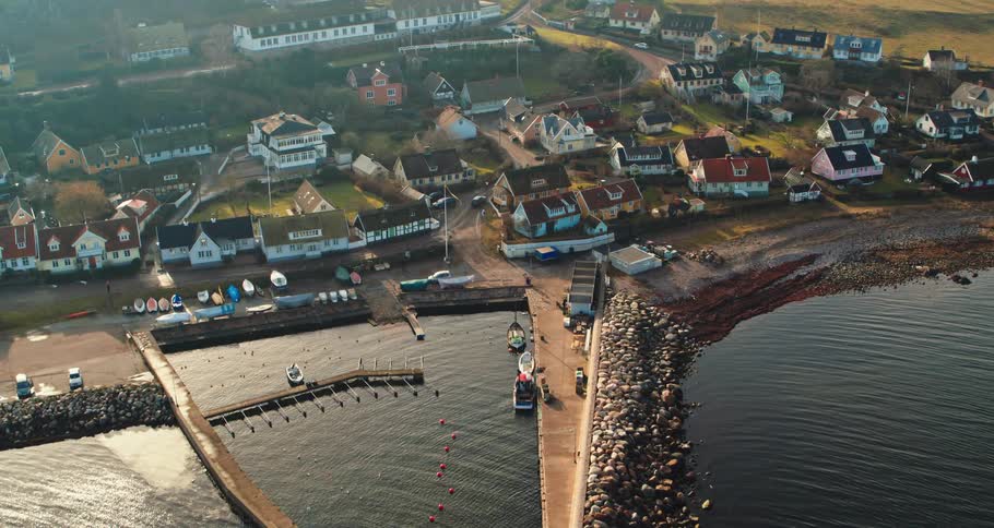 Aerial view of the bay in front of a a calm small coastal town close to the ocean at morning