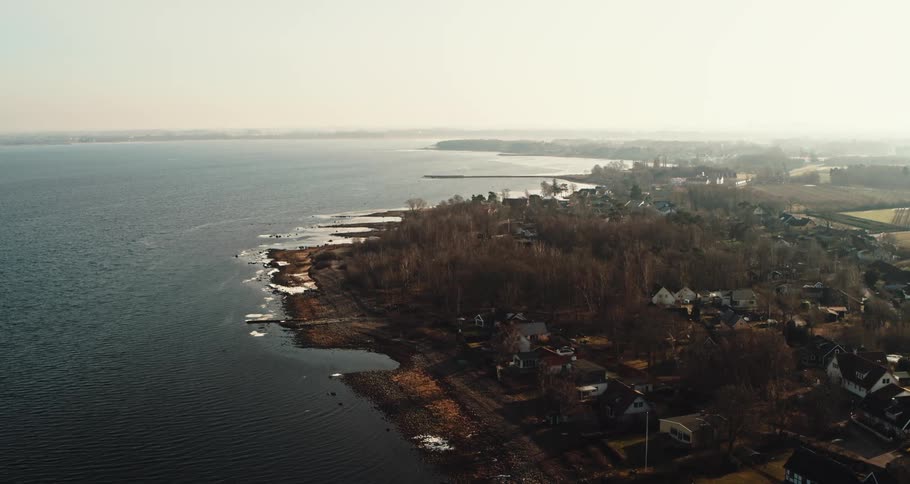 Aerial view of a city near the coast of an ocean is displayed