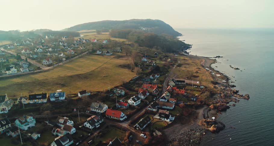 Aerial view of coastal town with detached houses next to ocean