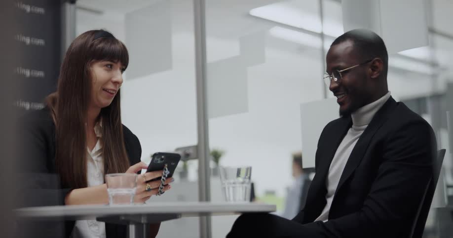Two people having a pleasant conversation on a cafeteria table in the office