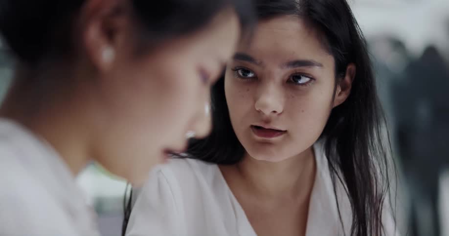Two coworker women talking in an office space