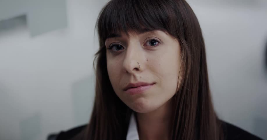 Woman wearing business attire turns around to look at the camera