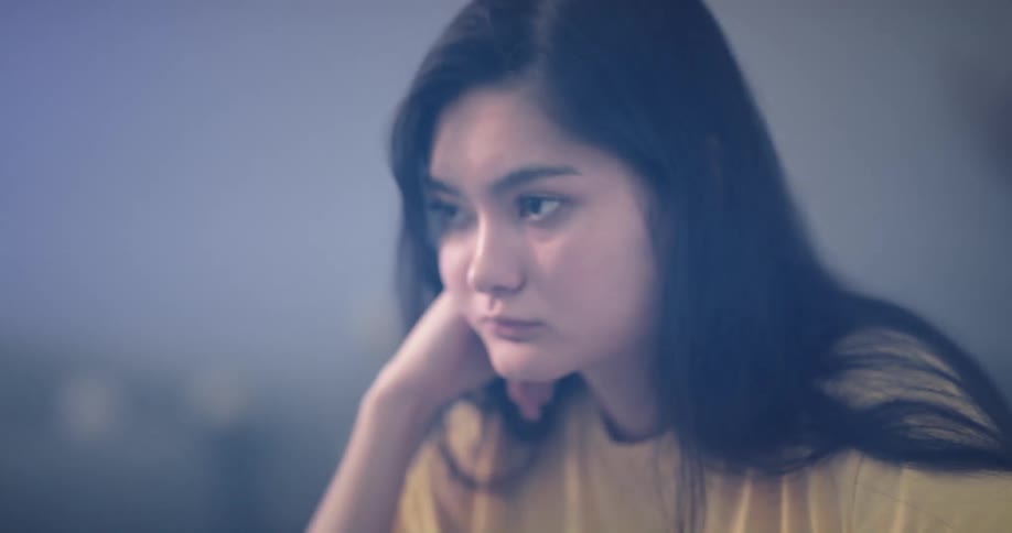 Bored asian girl leaning on her hand