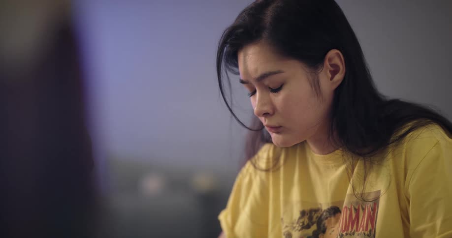 Young teenage woman concentrates while working or studying at home