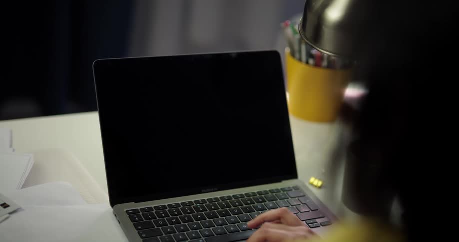 A person is typing on a laptop indoors