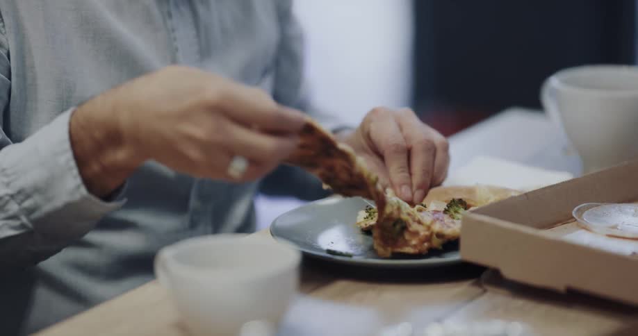Office workers sharing a pizza and some food in a meeting table on a office space