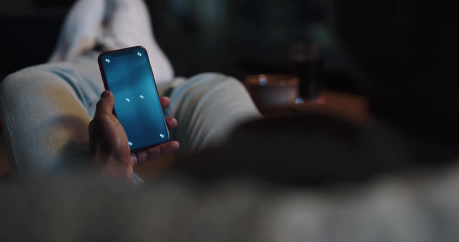 Person relaxing while scrolling through social media on cell phone