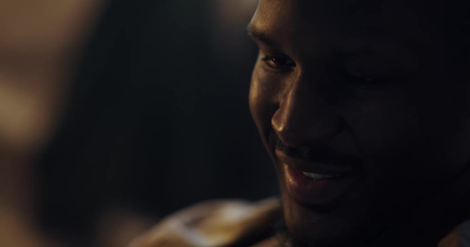 A man is smiling and sitting indoors in his house
