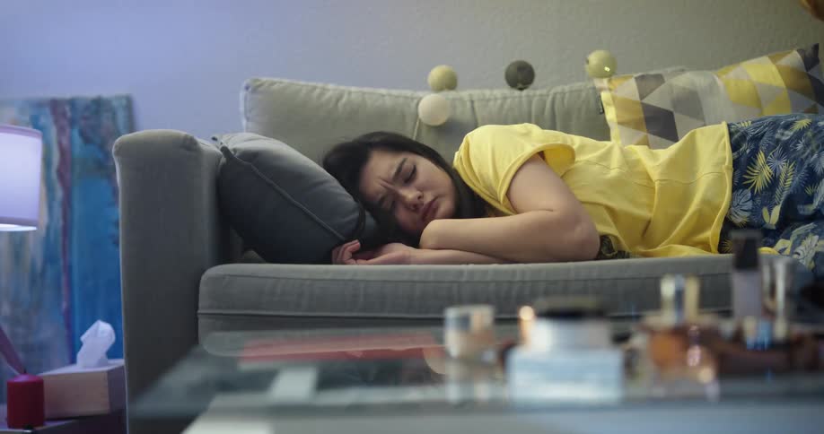 Young asian woman sleeping on the couch of her house