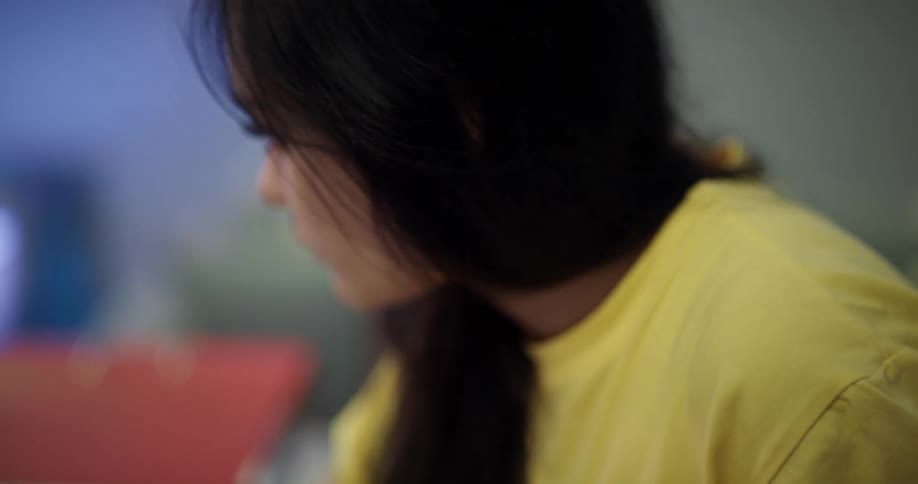 A woman is concentrating on an object indoors