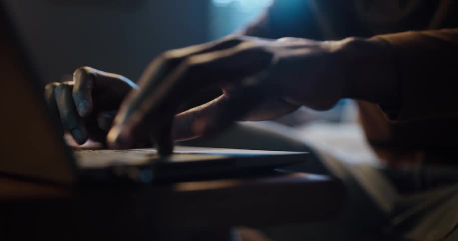 Someone is typing on the keyboard of a laptop computer