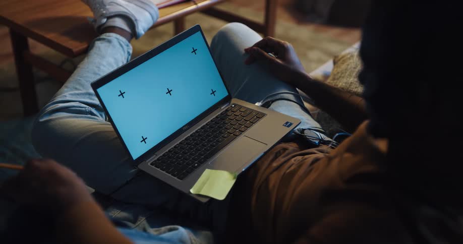 Man wearing a headset sitted on the couch with his laptop on his lap