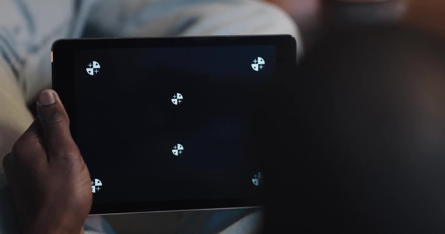 A man uses a computer tablet while relaxing indoors
