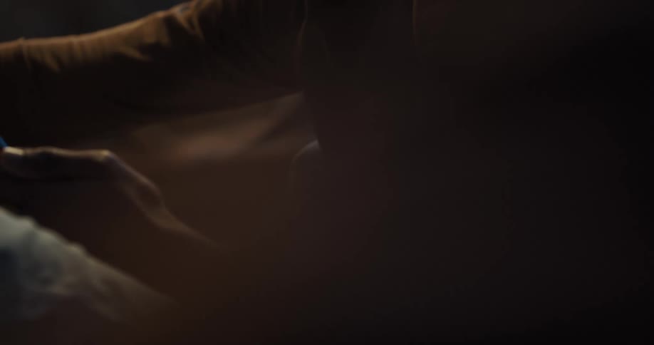 A man texts on his phone while sitting on the couch