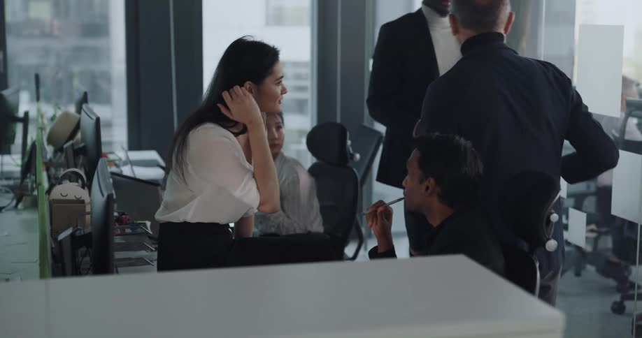 Coworkers chat as others move around office