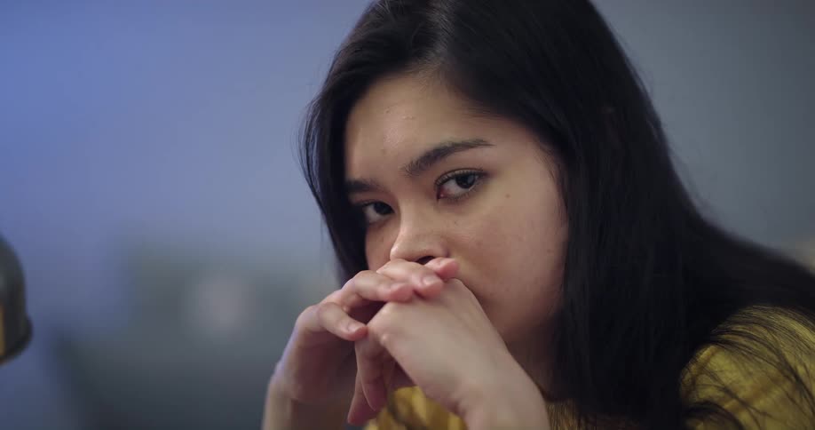 Young woman working at home turns around to look at the camera