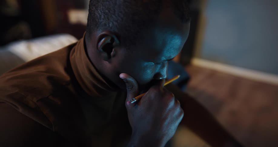 Young man sitting in the bedroom at home thinking while sitting in front of a computer