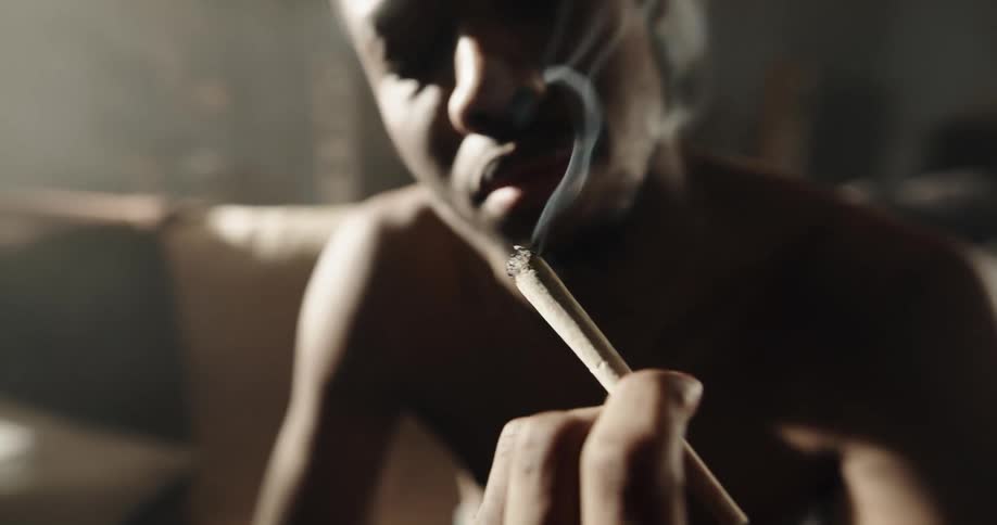 A man is smoking a cigar indoors