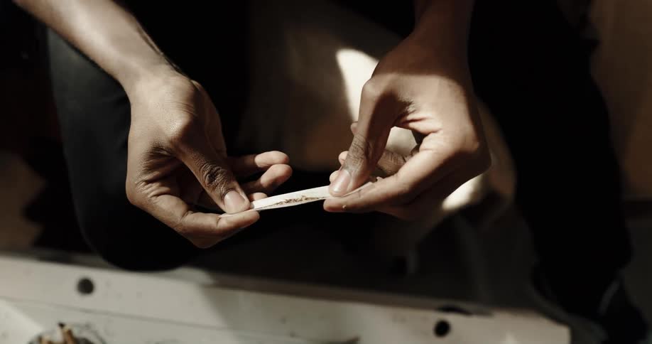 Tobacco is being placed in a piece of cigarette paper