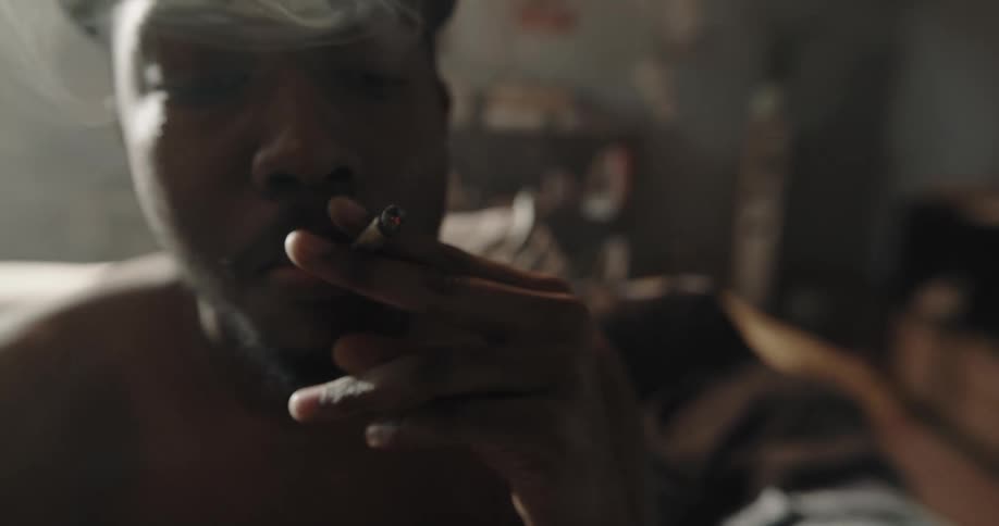 A man is smoking drugs at home
