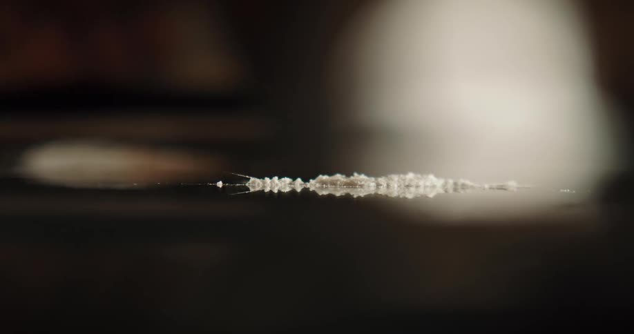A man is making a line of cocaine on a mirror