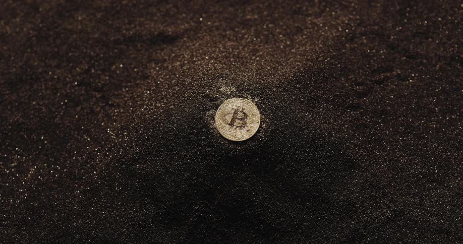 Bitcoin crypto token lies on gold dust