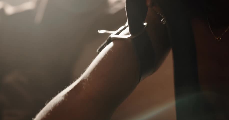 Man secures a belt around his upper arm then injects himself with a needle