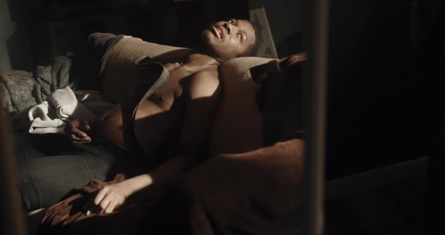 Man lies back with one hand on cylinder and belt across his chest