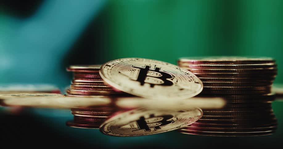 Stack of golden coins with the bitcoin logo printed on them