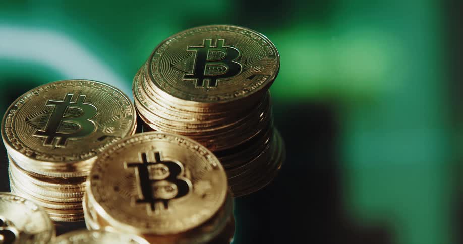 Stacks of golden coins with the bitcoin logo printed on them