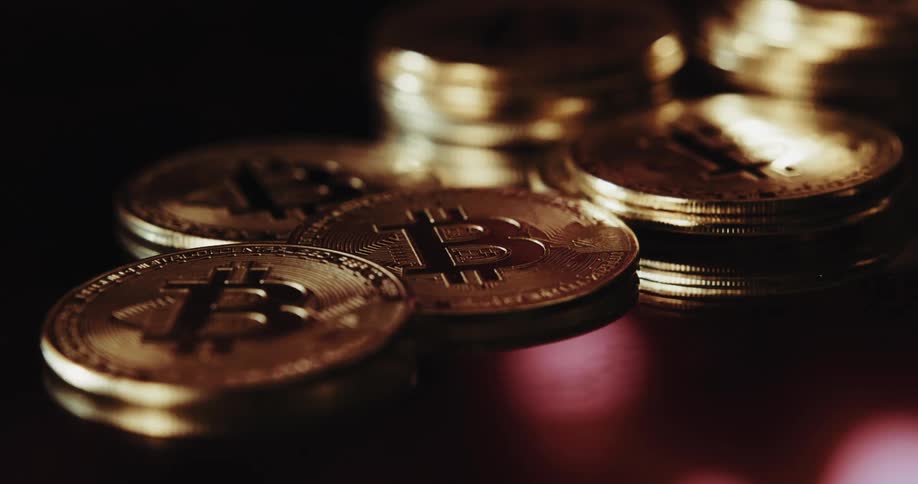 A pile of gold coins on a reflective surface