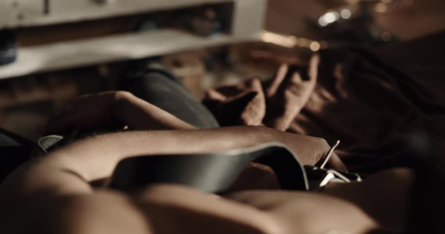 Man lies back with a belt cinched tightly around his arm