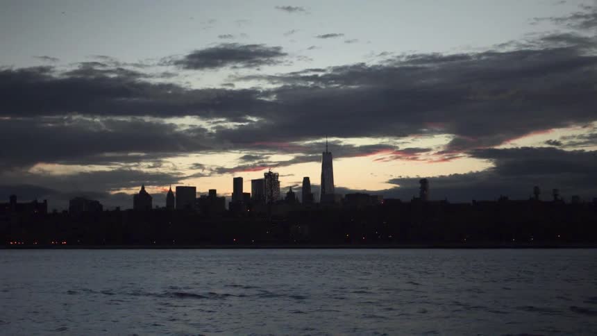 Across the water a city sits at sunset