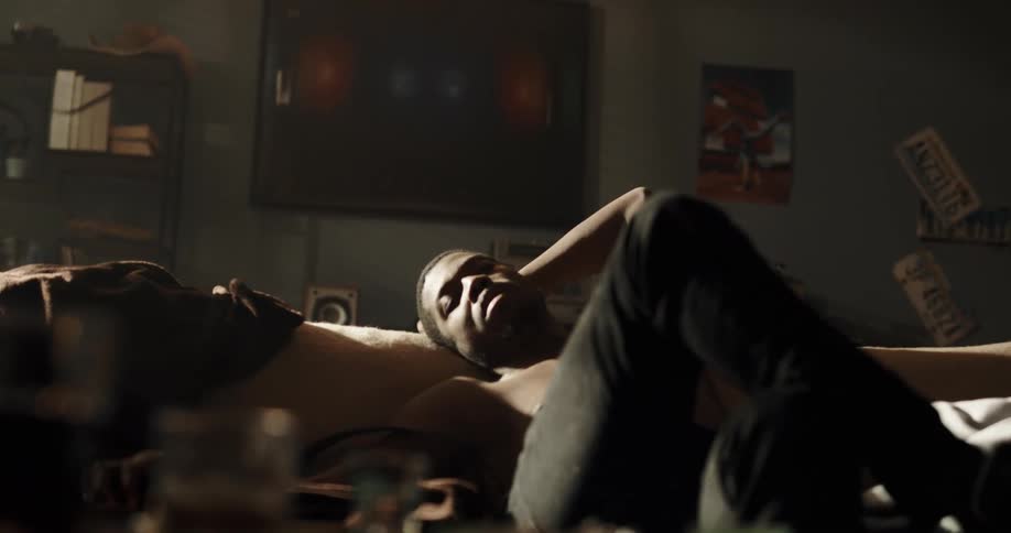 Young tired man reclined on the couch in the living room smoking a cigarette