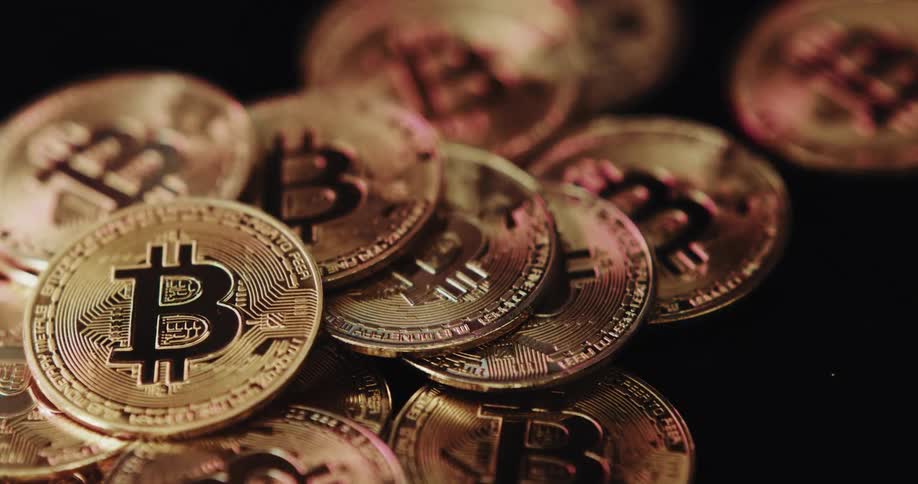 Gold bitcoins reflect light that shines on them
