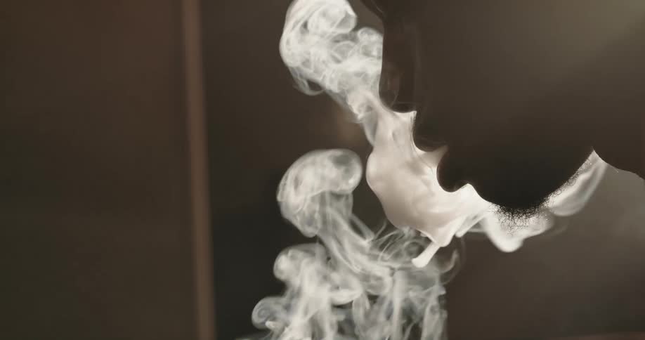 Man smokes a cigarette and makes the room smokey