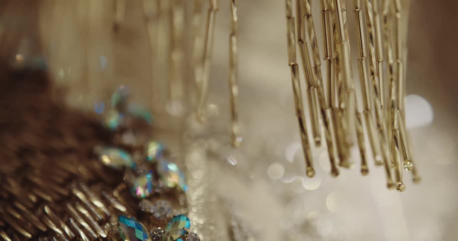 Gold metal fringe hanging and swaying above shimmering gems