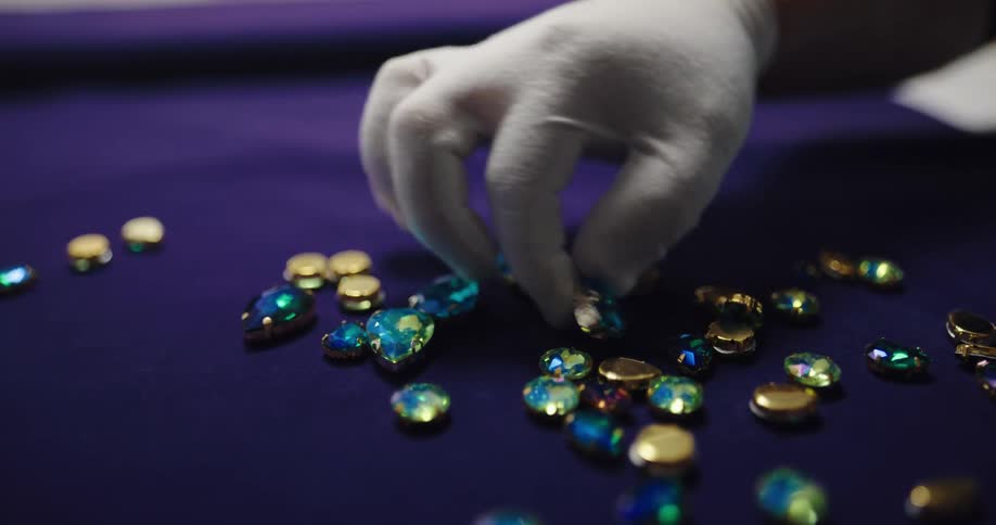 A man pours gems on a tabletop to examine